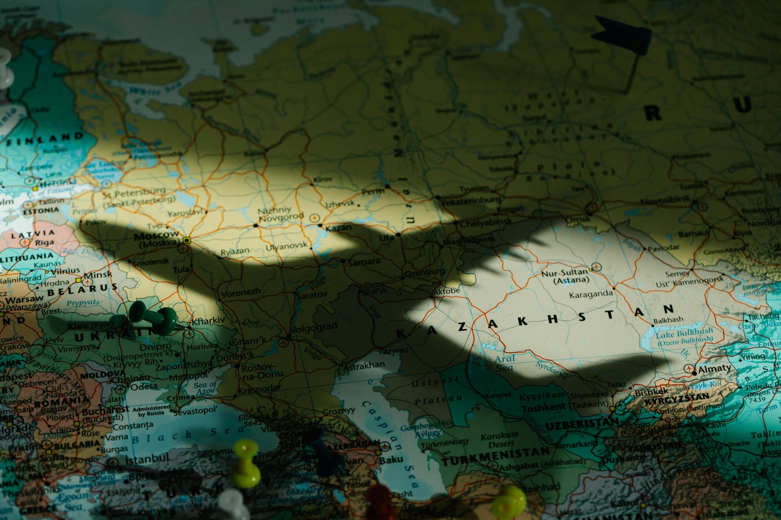 Shadow of a toy airplane on a detailed map of Eastern Europe highlighting Kazakhstan.